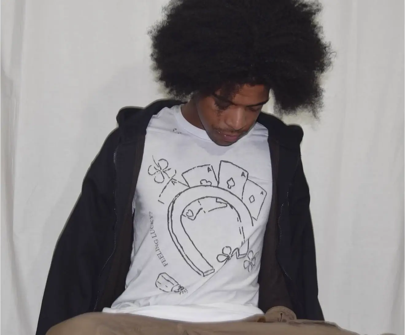 White “Feeling Lucky” T-shirt with a playing-card and horseshoe graphic, shown being worn