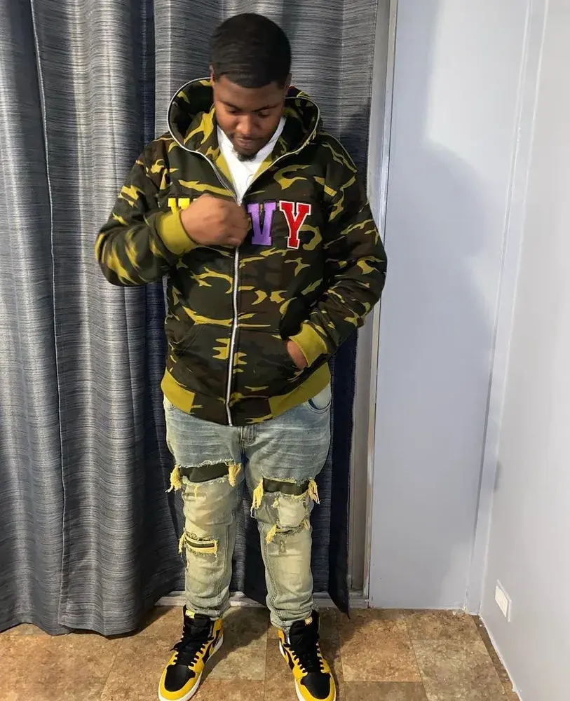 A wearer pictured in a camouflage WavyNavy hoodie.