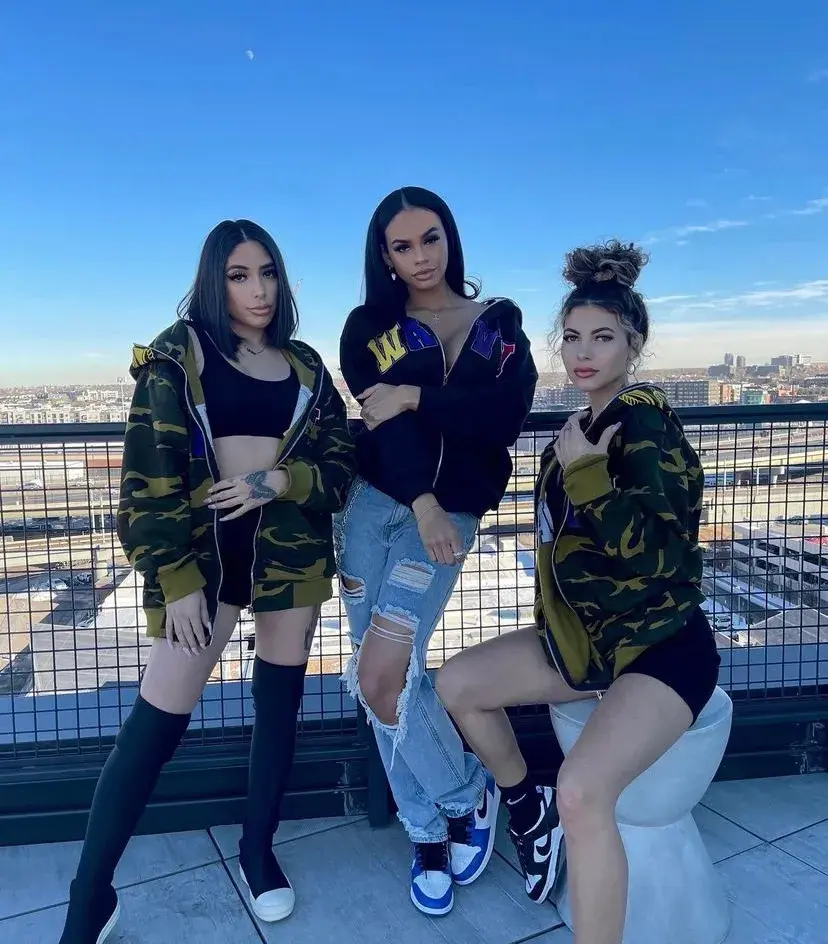 Group photograph on a rooftop featuring camouflage and black hoodies.