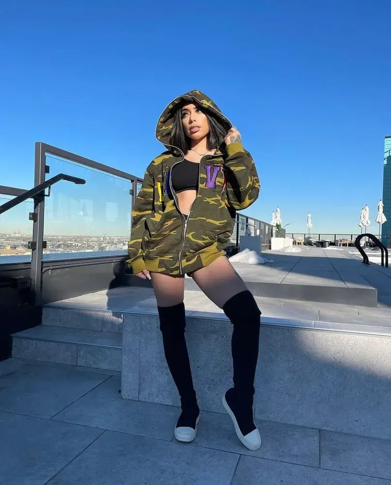 A wearer pictured in a camouflage WavyNavy hoodie outdoors.