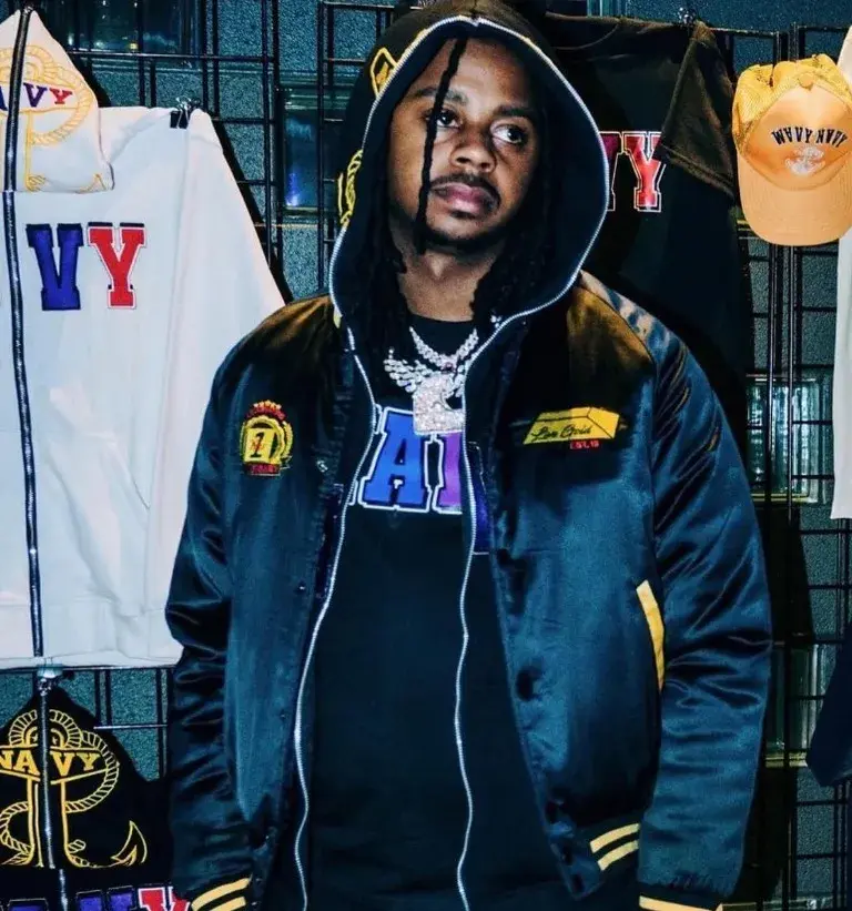 A wearer in a dark jacket in front of a display of WavyNavy garments.